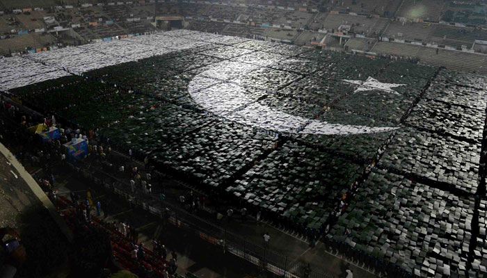 Pakistani youths make human national flag at the National Hockey Stadium in Lahore on October 22, 2012. — AFP