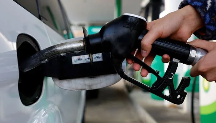 A person uses a fuel nozzle to fuel up a car at a petrol station in Vienna, Austria March 18, 2022. — Reuters