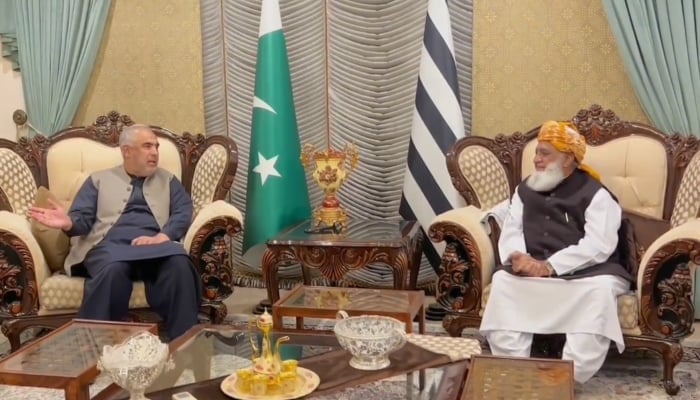 Jamiat Ulema-e-Islam-Fazl (JUI-F) chief Maulana Fazl-ur-Rehman (R) and Pakistan Tehreek-e-Insaf (PTI) leader Asad Qaiser (L) talking at the formers residence. —@juipakofficial/Screengrab
