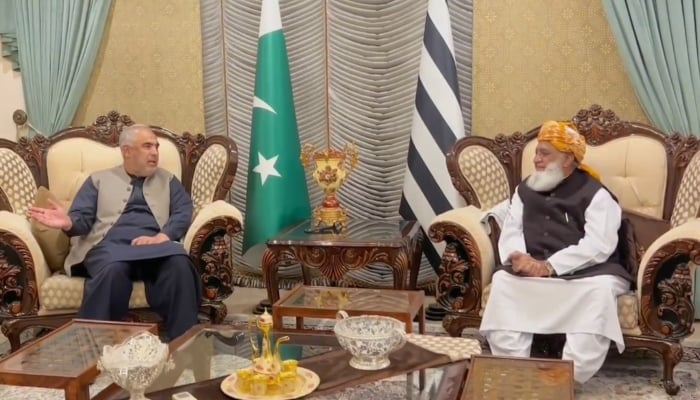 Jamiat Ulema-e-Islam-Fazl (JUI-F) chief Maulana Fazl-ur-Rehman (R) and Pakistan Tehreek-e-Insaf (PTI) leader Asad Qaiser (L) talking at the formers residence. —@juipakofficial/Screengrab