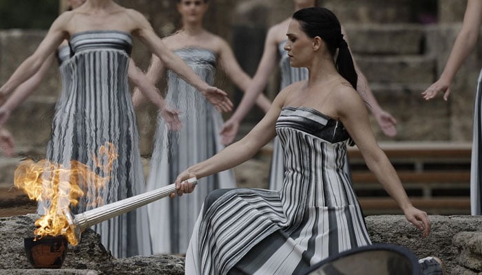 Greek actress Mary Mina lits the torch during the Olympic Flame lighting ceremony for the Paris 2024 Olympics. — Reuters