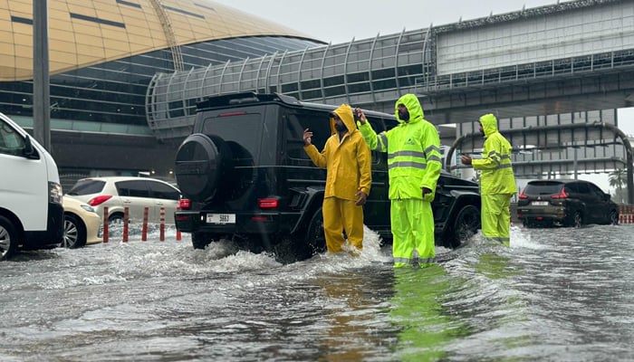 This image released on April 16, 2024, shows officials of Dubai Municipality responding to an emergency in Dubai. — X/@DXBMediaOffice