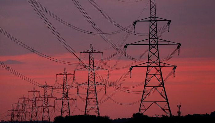 The sun rises behind electricity pylons near Chester, northern England October 24, 2011. — Reuters