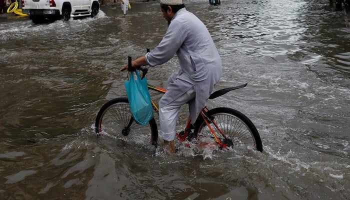A man rides bicycle along a flooded road, following heavy rains during the monsoon season in Karachi, Pakistan July 25, 2022. —Reuters