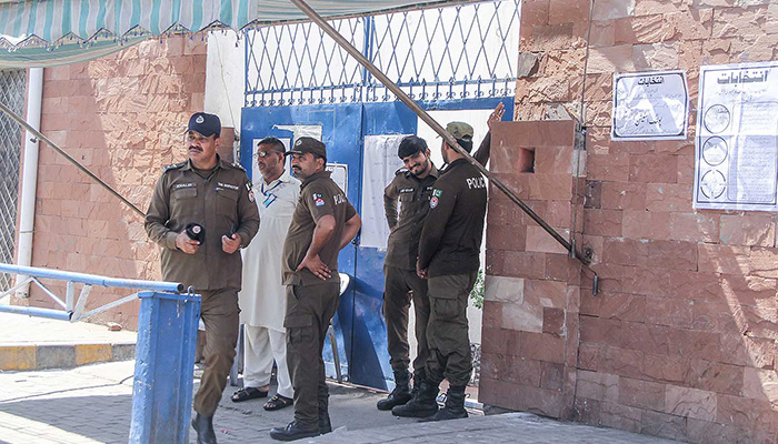 Security officials standing outside a polling station in Lahore during by-elections on April 21, 2024. — NNI