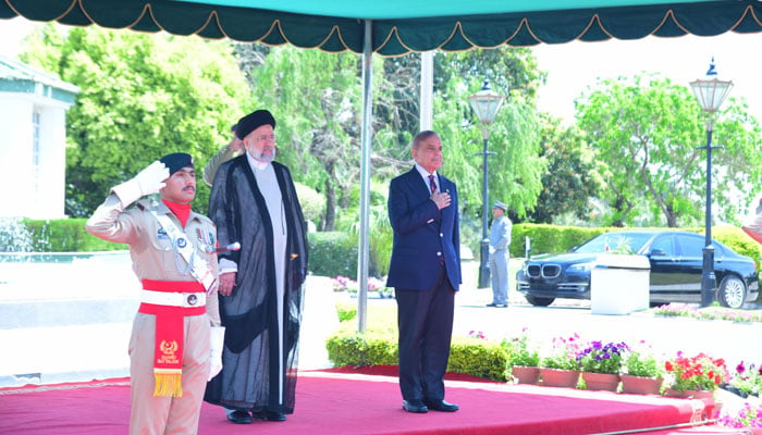Iranian President Seyyed Ebrahim Raisi (left) and Prime Minister Shehbaz Sharif observe the guard of honour in Islamabad on April 22, 2024. — PMO