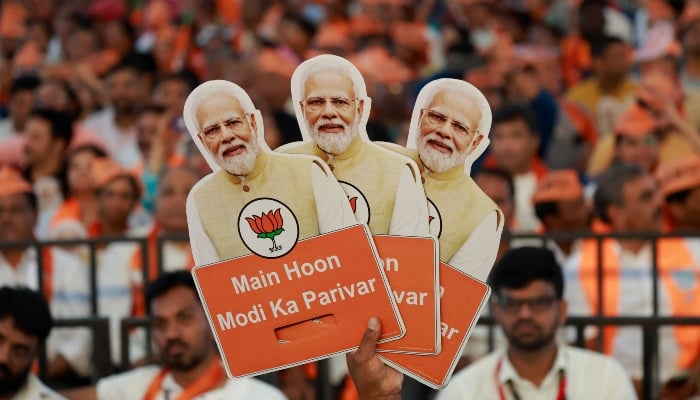 A supporter of Indias ruling Bharatiya Janata Party (BJP) holds cutouts of Prime Minister Narendra Modi’s image during an election campaign where Modi speaks, in Bengaluru city of India’s Karnataka state, on April 20, 2024. —Reuters