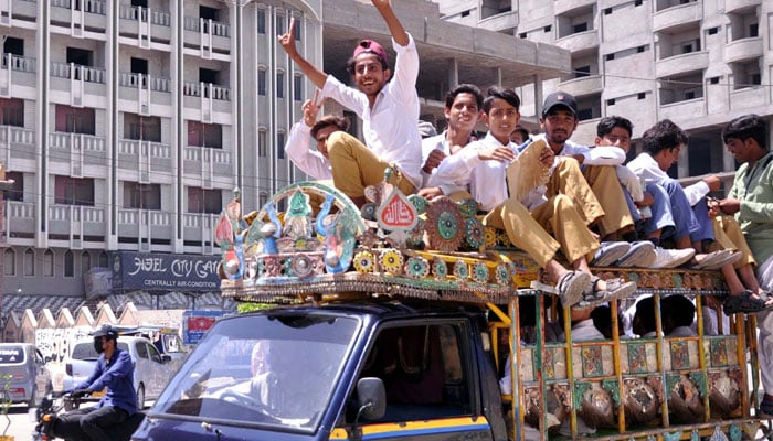 Students are seen commuting on an overloaded van in Hyderabad on April 23, 2024. — PPI