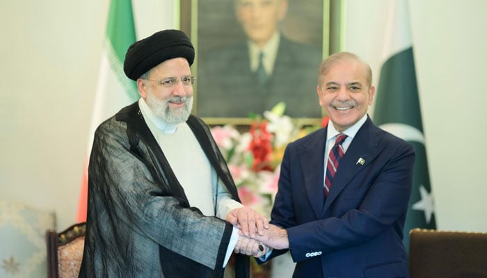 Iranian President Seyyed Ebrahim Raisi (left) and Prime Minister Shehbaz Sharif shakes hands during their meeting in Islamabad on August 22, 2024. — APP