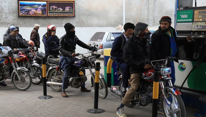 People wait for their turn to get fuel at a petrol station, a day after a country-wide power breakdown, in Peshawar, on January 24, 2023. — Reuters
