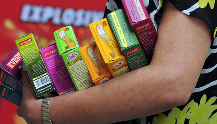 In this photograph taken on July 7, 2014, an Indian shopper holds packets of spices as she browses at a supermarket in Mumbai. — AFP