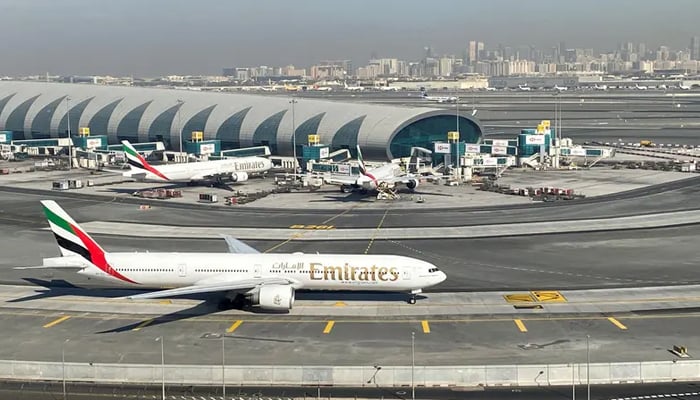 متحدہ عرب امارات کے دبئی میں دبئی انٹرنیشنل ایئرپورٹ کے عمومی منظر میں امارات کے ہوائی جہاز ٹرمک پر نظر آتے ہیں۔  - رائٹرز