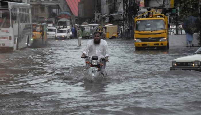 A man rides on a motorcycle amid flood waters along a road during the monsoon season in Rawalpindi, Pakistan July 19, 2023. — Reuters