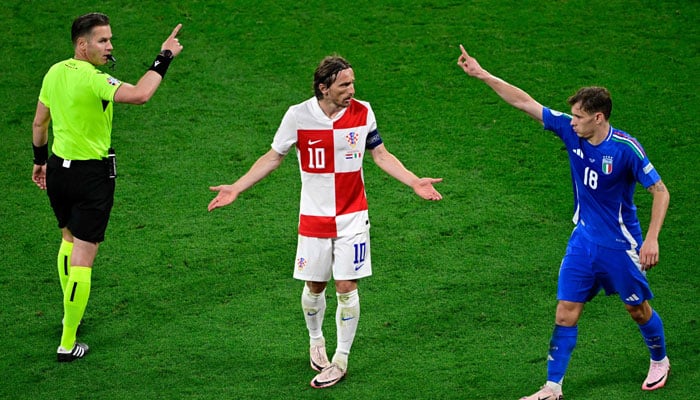 Dutch referee Danny Makkelie interacts with Croatias midfielder #10 Luka Modric and Italys midfielder #18 Nicolo Barella during the UEFA Euro 2024 Group B football match between Croatia and Italy at the Leipzig Stadium in Leipzig on June 24, 2024. — AFP