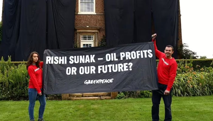 The file image shows Greenpeace activists displaying a banner against oil and gas licenses after they covered UK PM Rishi Sunak’s home with black cloth. — Greenpeace