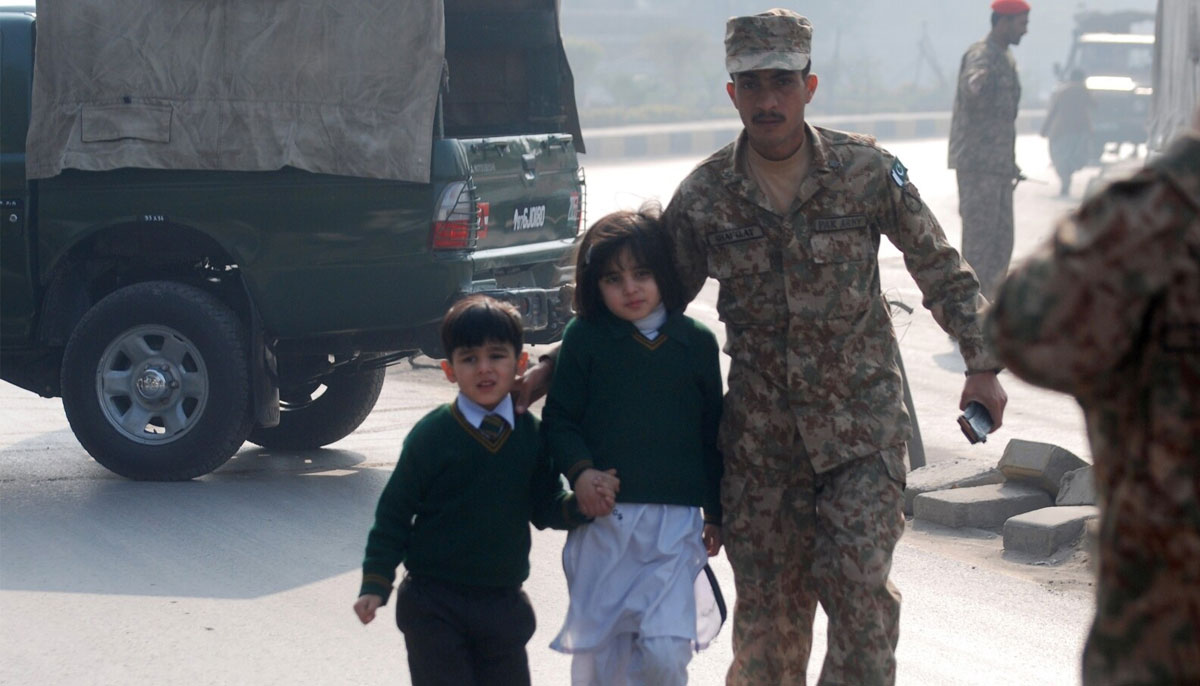 A soldier escorts schoolchildren from the Army Public School that was attacked by Taliban gunmen in Peshawar, Pakistan, Dec. 16, 2014. — Reuters