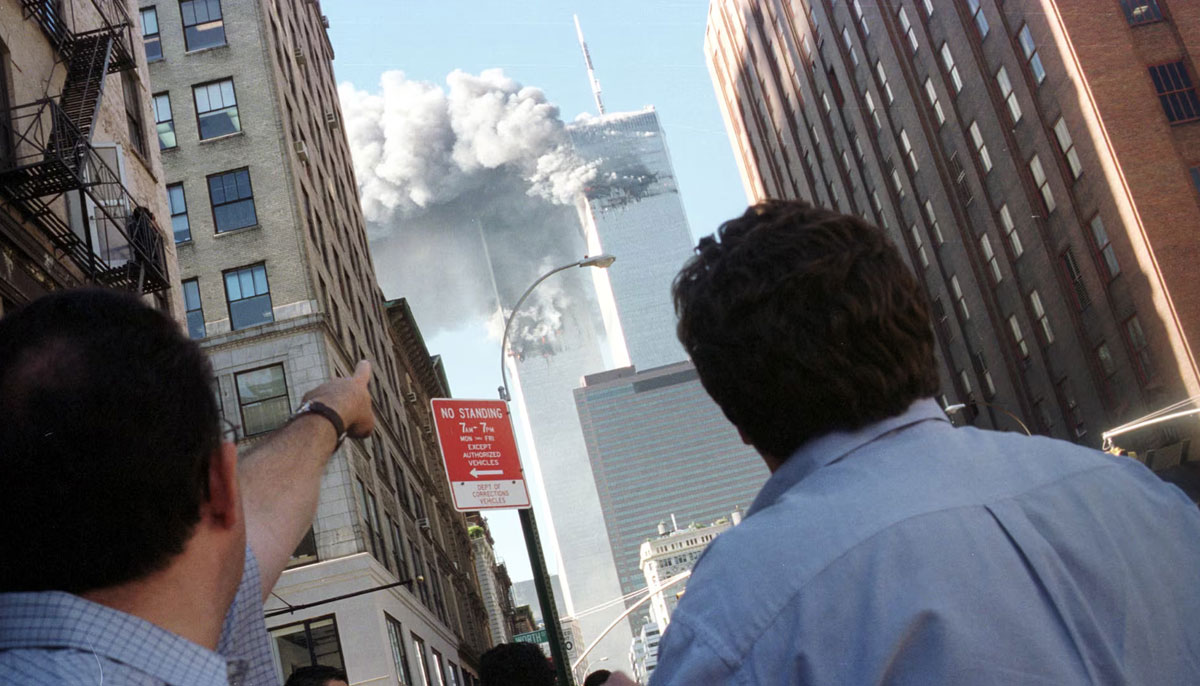 Pedestrians react to the World Trade Center collapse, September 11, 2001. — Reuters