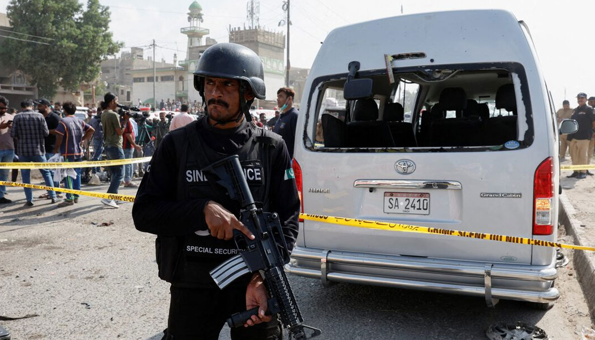 A police officer stands guard near a cordoned damaged vehicle at the site after a suicide blast in Karachi, Pakistan April 19, 2024. — Reuters