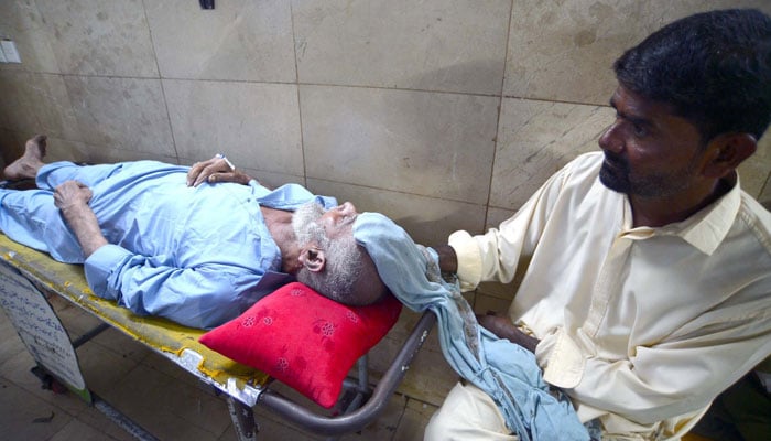 An elderly patient of heatstroke awaits treatment at Civil Hospital in Karachi, Pakistan on June 26, 2024. — APP