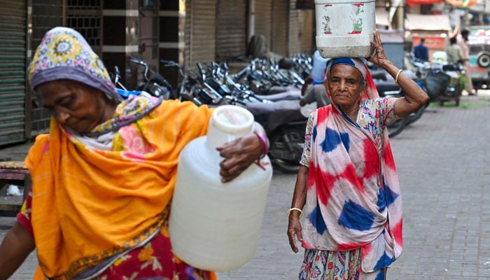Women carry drinking water in jerrycans, in Karachi, Pakistan on June 7, 2024. — AFP