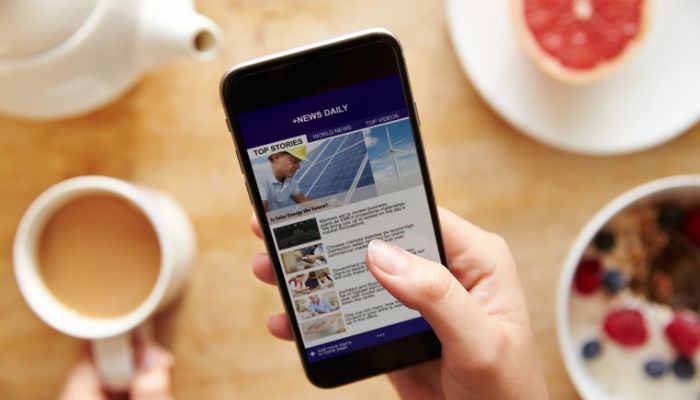 A representational image of a person reading news on a phone. — Canva