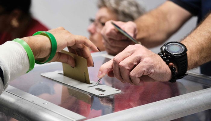 A woman casts her ballot as she votes at a polling station inside the Koutio town hall during the first round of Frances crunch legislative elections in Dumbea in the second constituency of the French Pacific territory of New Caledonia, on June 30, 2024. — AFP