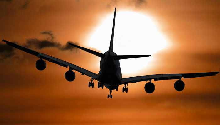 This representational image shows a sillhouette of an aircraft in flight. — Pexels