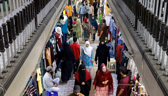 People walk as they shop in a market in Karachi, on April 19, 2023. — Reuters