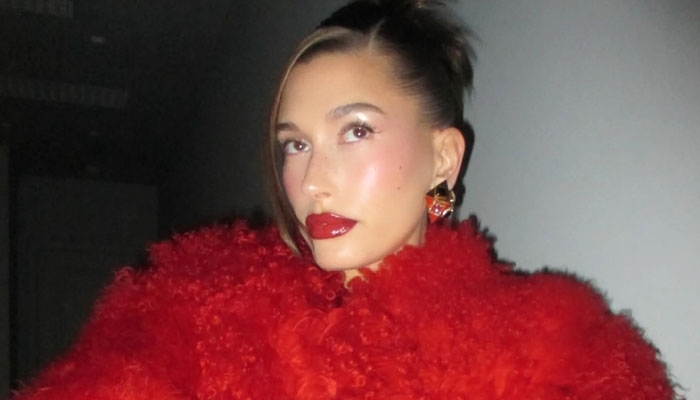 Hailey Bieber shows off her baby bump as she dons red