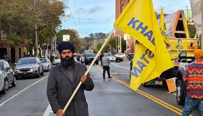 Satinder Pal Singh Raju stands holding the flag of Khalistan. — Photo by reporter