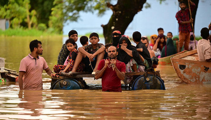 People wade through flood waters in Feni, Bangladesh on August 23, 2024. — AFP