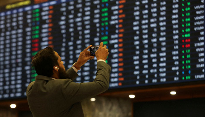 A broker takes a picture of the trading screen at the Pakistan Stock Exchange. – Reuters/File