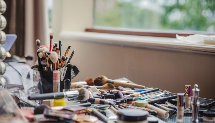 A representational image of a clutter of cosmetics on a table. — Unsplash/file