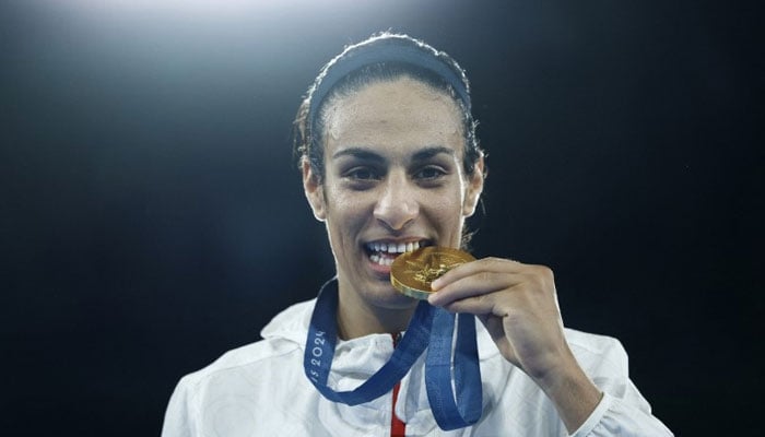 Gold medallist Imane Khelif of Algeria bites her medal. — Reuters/file