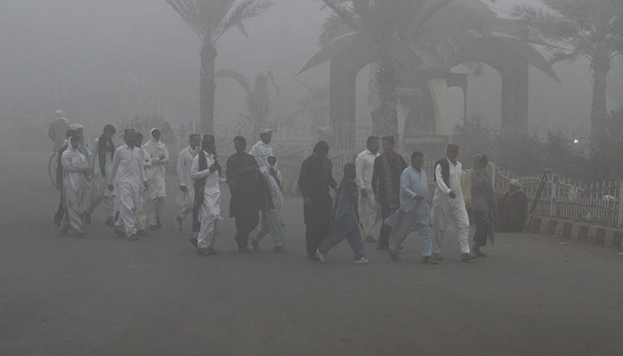 People walk amid thick smog along a road in Multan, Pakistan November 9, 2024. — Reuters