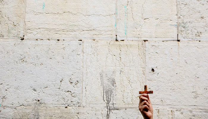 A worshipper holds up a cross during the Good Friday procession at the Via Dolorosa in Jerusalems Old City, March 29. — Reuters