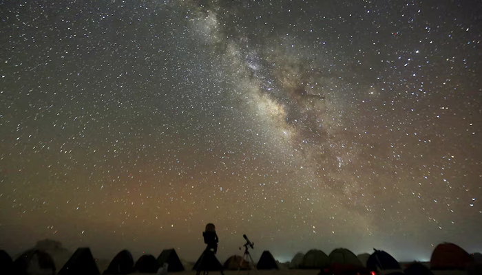 The Milky Way is seen in the night sky around telescopes and camps of people over rocks in the White Desert north of the Farafra Oasis southwest of Cairo May 16, 2015. — Reuters