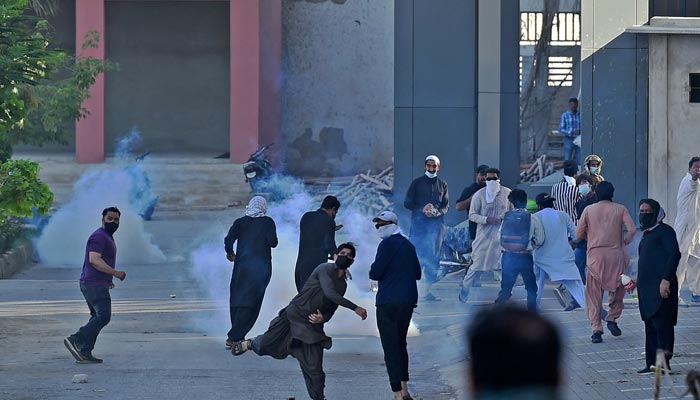 PTI activists and supporters of former Pakistan´s Prime Minister Imran Khan clash with police during a protest against the arrest of their leader, in Karachi on May 10, 2023. — AFP