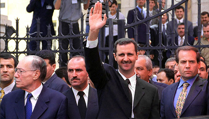 Syrias President Bashar al-Assad (C) waves to supporters outside the parliament in Damascus on July 17, 2000, after taking the oath of office. — AFP