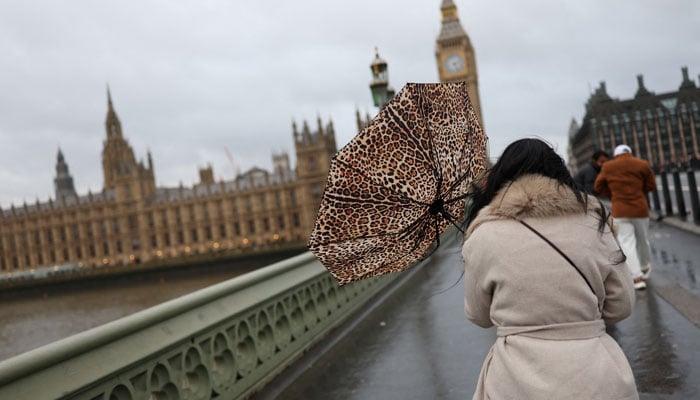 A woman holds her umbrella during a gust of wind on Westminster Bridge after Storm Darragh hit the country, in London, Britain, December 7, 2024. — Reuters