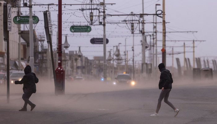 People walk against strong wind after Storm Darragh hit the country in Blackpool, Britain, December 7, 2024. — Reuters