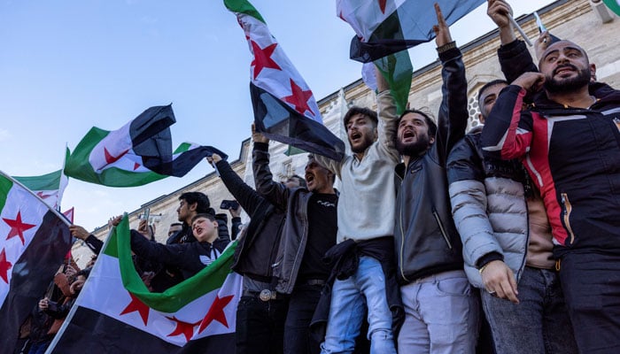 Syrians living in Turkey with opposition flags celebrate after Syrian rebels announced that they have ousted President Bashar al-Assad, in front of the Fatih Mosque in Istanbul, Turkey on December 8, 2024. — Reuters