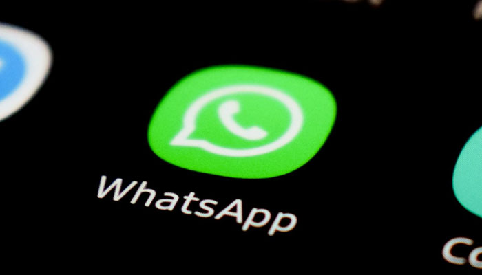 A representational image shows the WhatsApp icon displayed on a phone screen. — Unsplash