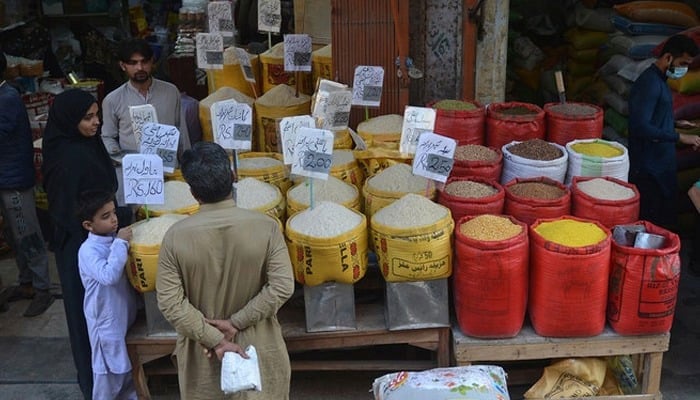 People buy pulses and cereals at a wholesale market in Karachi on February 1, 2023. — AFP