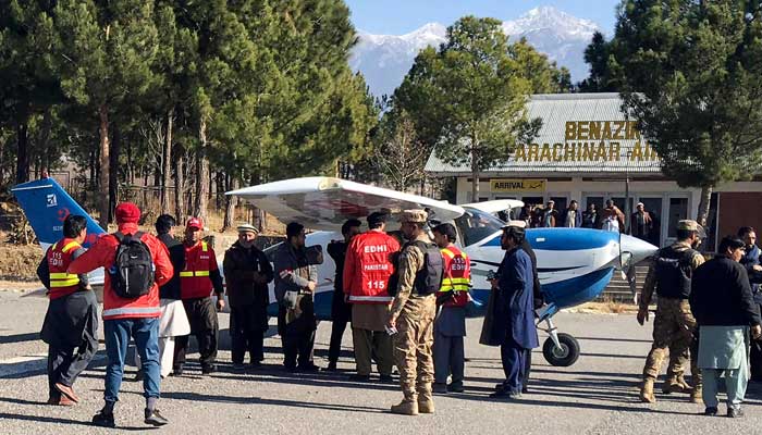 Volunteers of private welfare organisation Edhi with security personnel surround aplane carrying medicines for victims injured in clashes, upon its arrival in Parachinar, at Kurram district, Khyber Pakhtunkhwa on December 17, 2024. — AFP