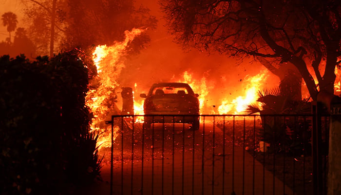 A parked vehicle is surrounded by flames as powerful winds fueling devastating wildfires in the Los Angeles area force people to evacuate, at the Eaton Fire in Altadena, California, US on January 8, 2025. — Reuters