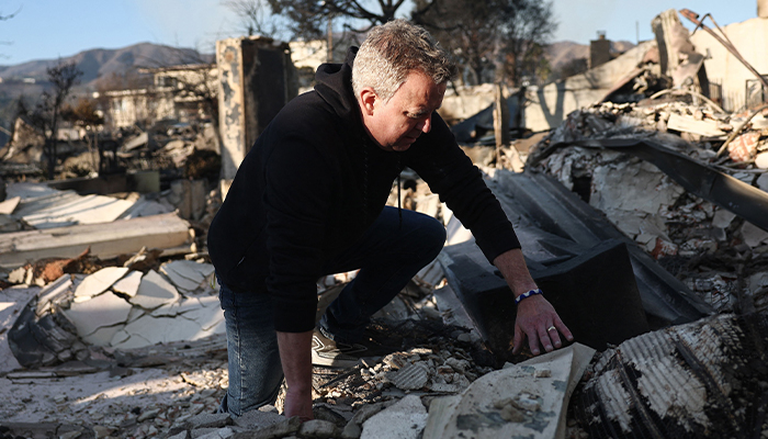 Revenant John Shaver climbs through the remains of Community United Methodist Church, while visiting for the first time since it was destroyed in the Palisades Fire on January 10, 2025 in Pacific Palisades, California. — AFP