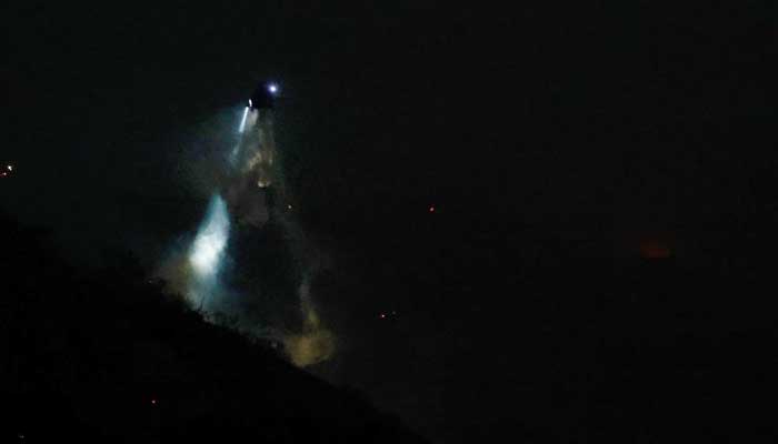 A night helicopter drops water on the Palisades Fire near Mandeville Canyon, in Brentwood, Los Angeles County, California, US, January 11, 2025. — Reuters