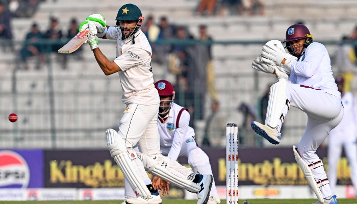 Shan Masood (left) plays a shot as West Indies wicket-keeper Tevin Imlach reacts during the first Test match between Pakistan and West Indies at the Multan Cricket Ground in Multan on January 18, 2025. – AFP