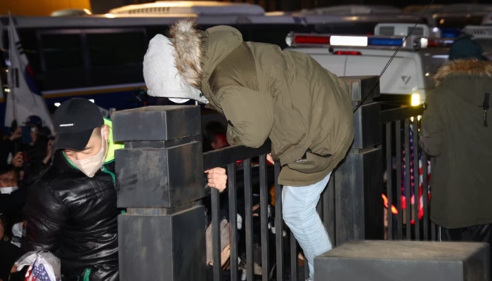 A pro-Yoon protester jumps over a fence of a court during a rally outside a court on the day South Koreas impeached President Yoon Suk Yeol plans to attend a court hearing to fight a request by investigators to extend his detention on accusations of insurrection, in Seoul, South Korea, January 18, 2025. — Reuters